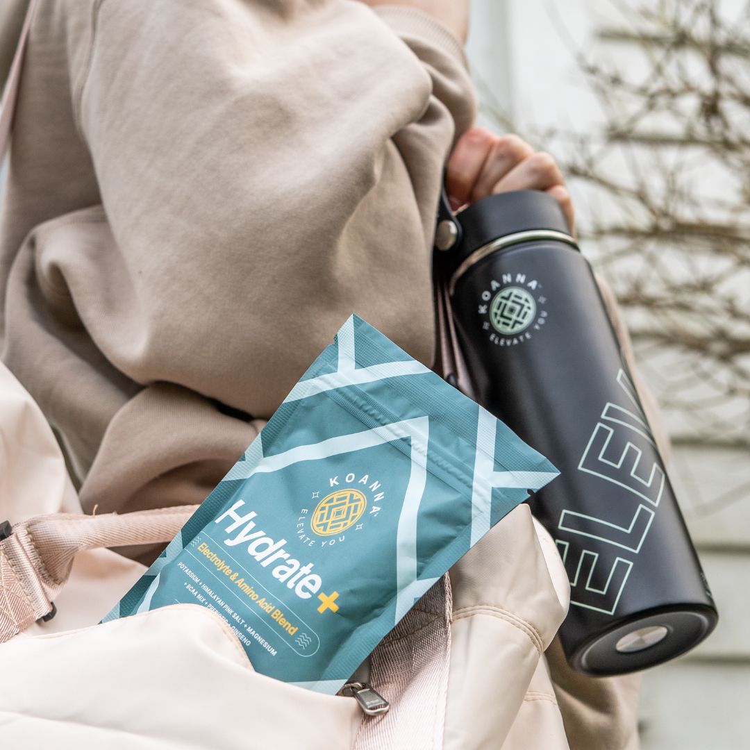 Woman on the go with Elevate bottle in hand and Hydrate+ in her bag.
