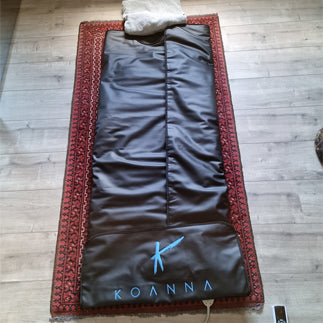 Koanna infrared sauna blanket on a rug