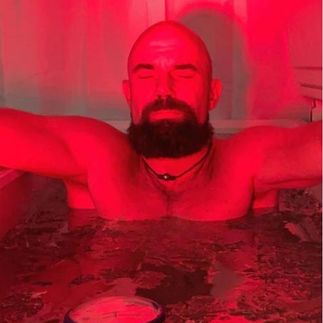 Man biohacking with red light therapy and ice bath