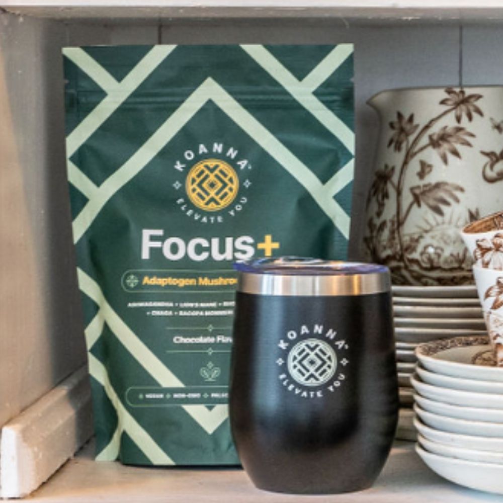 Elevate cup and Focus+ on a kitchen shelf next to dishes.